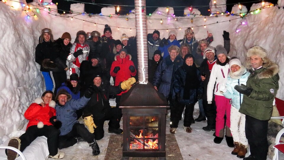 Une famille nombreuse autour d'un feu de foyer extérieur, l'hiver.