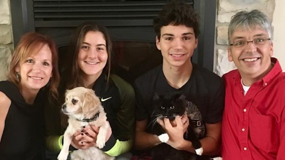 La famille Roy-Arseneault en compagnie de Bianca Andresscu assis devant le foyer.