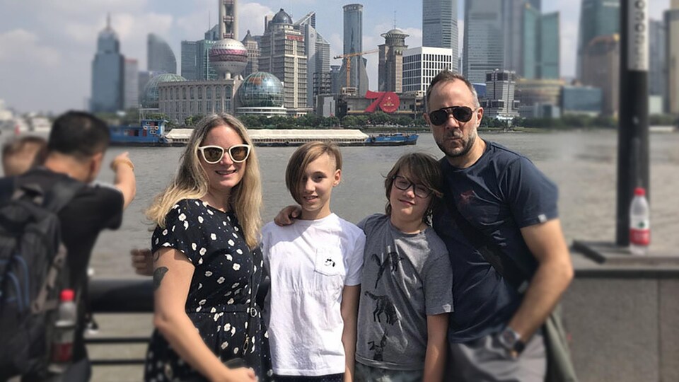 Une femme et un homme avec leurs deux enfants devant la ville de Shanghai.
