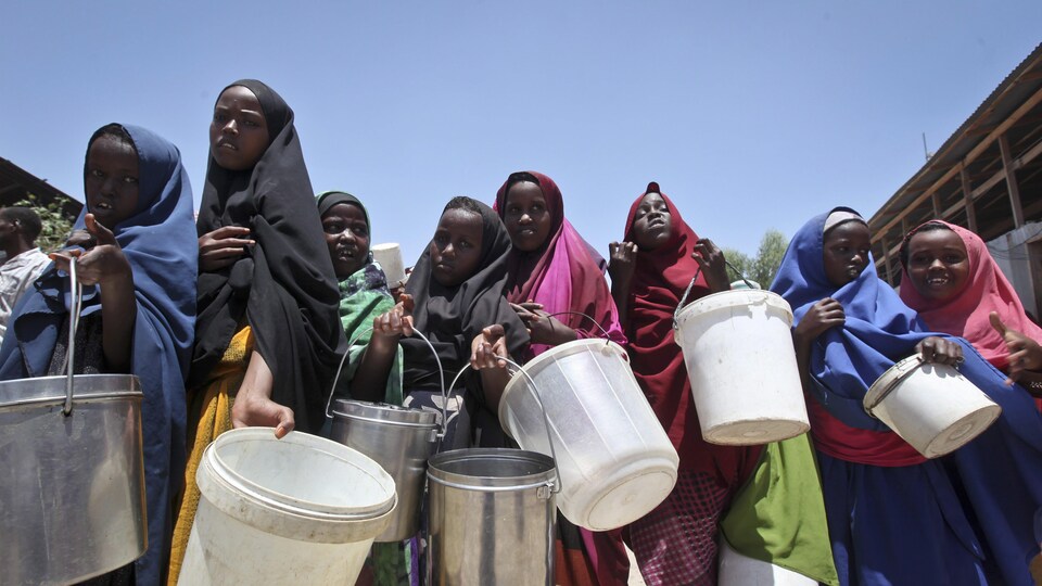 De jeunes Somaliennes attendent de la nourriture dans un camp de Mogadiscio, en Somalie