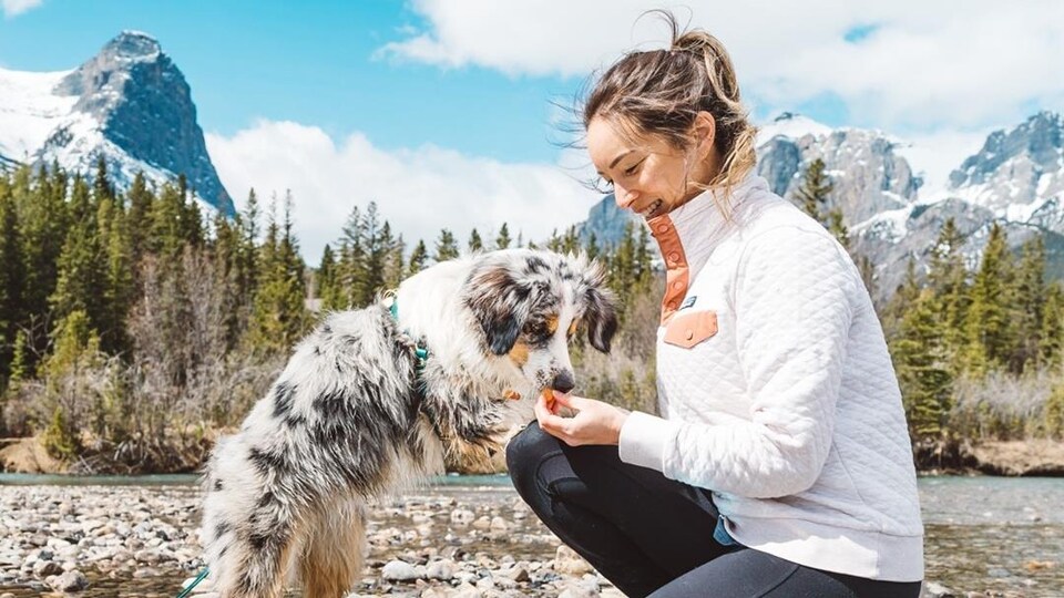 Victoria Stuart est agenouillée devant sa chienne Farley. Elle lui offre une gâterie.