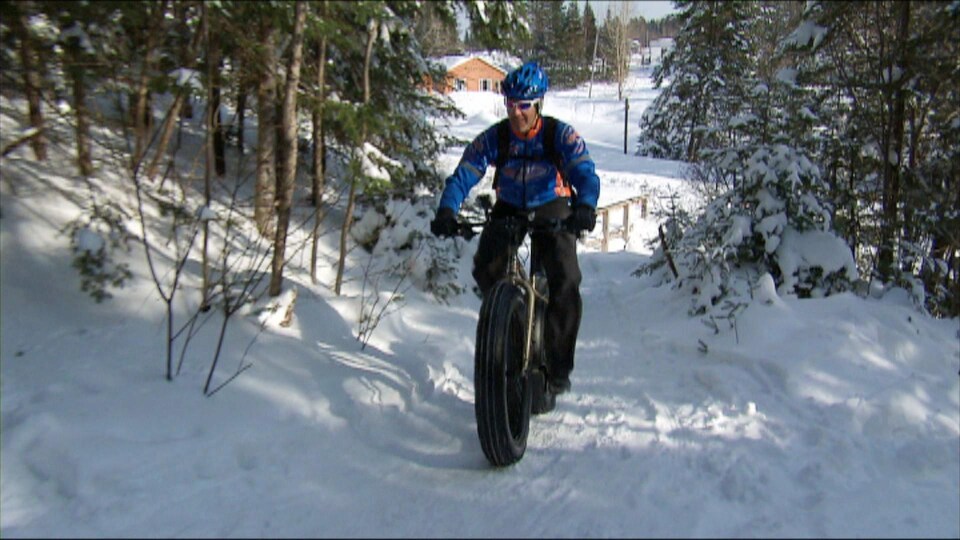 Cycliste dans un sentier de neige.