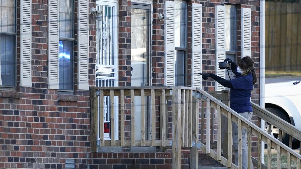 Une femme prend l'entrée d'une maison en photo.