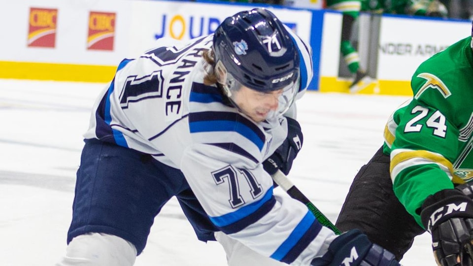 Des joueurs de hockey se disputent la rondelle.