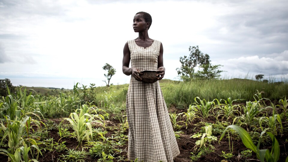 Une femme se tient au milieu de son champs. 