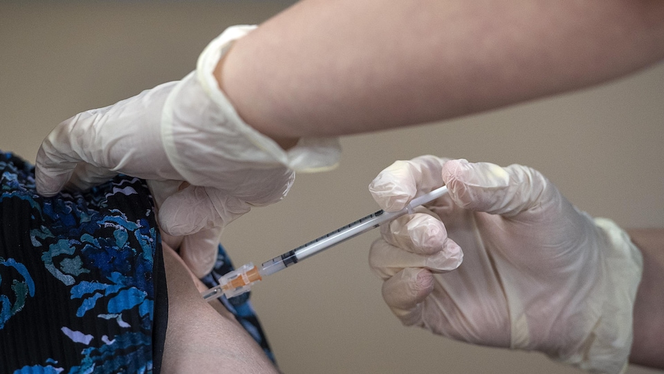 Une femme reçoit une dose d'un vaccin contre la COVID-19.