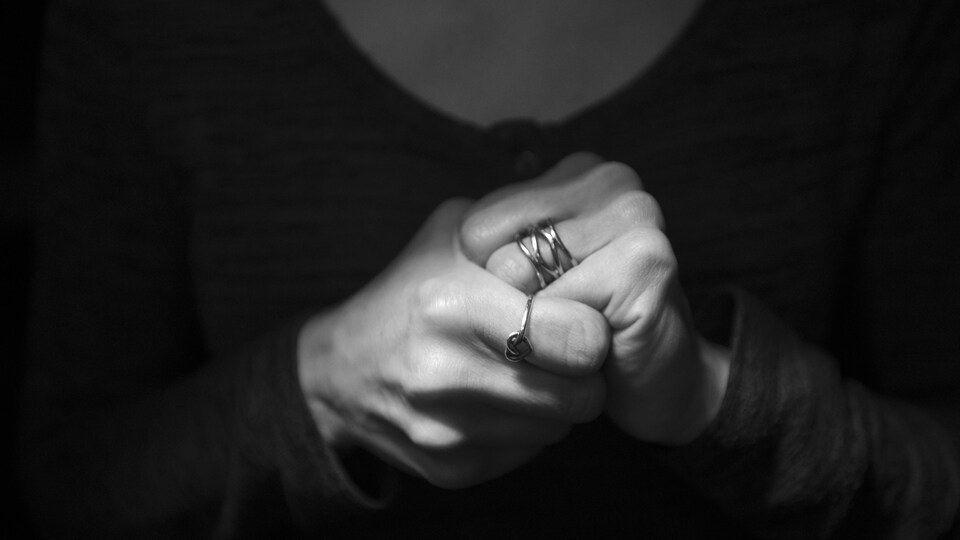 Une femme serre les mains d'angoisse.