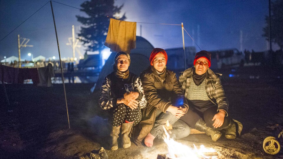 Des migrantes autour d'un feu de camp.