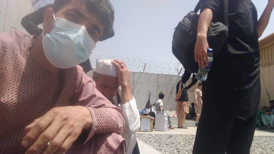Des hommes afghans viennent de franchir l'enceinte de l'aéroport de Kaboul, épuisés et affamés.