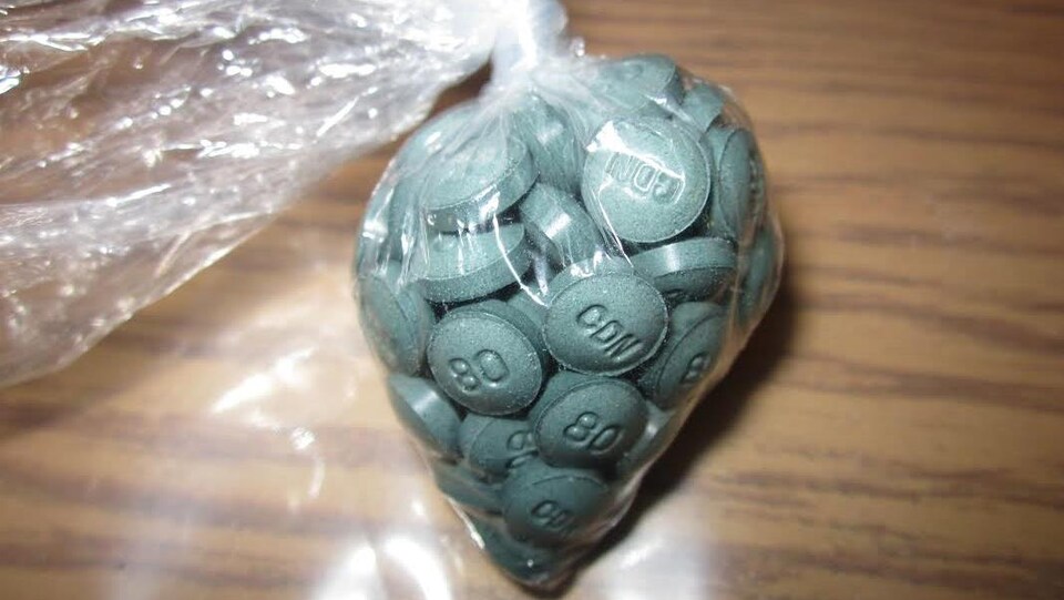 Des pilules bleues dans un sac de plastique
