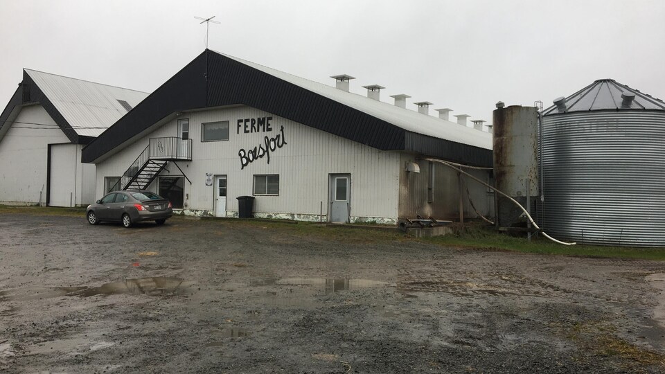 Le bâtiment de ferme avec un silo.