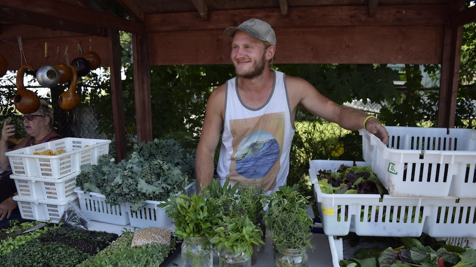 Frédéric Moisan Wilson pose devant sa récolte de légumes
