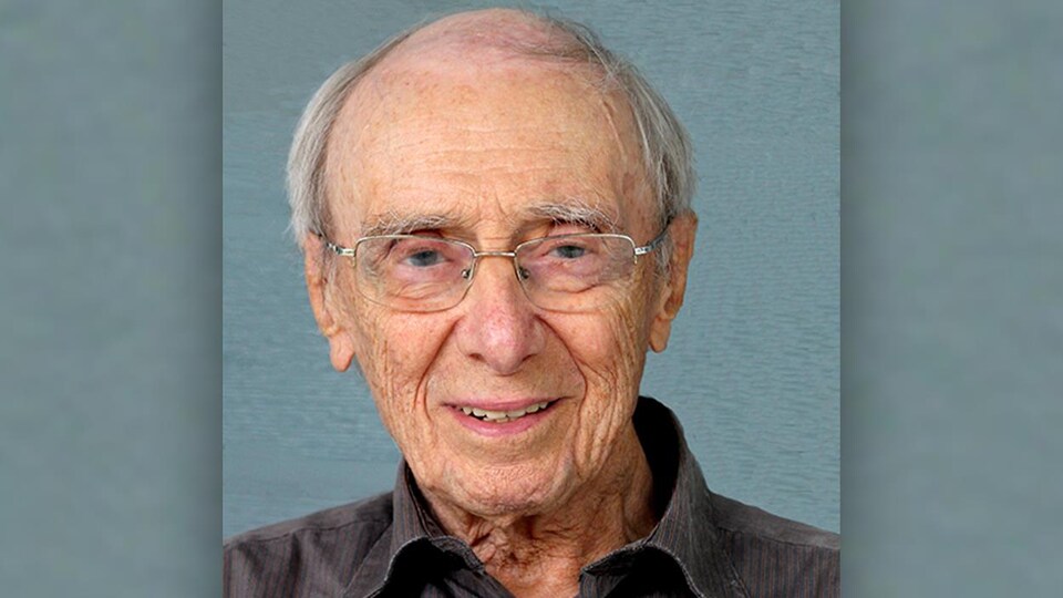 An old man wearing glasses smiled.