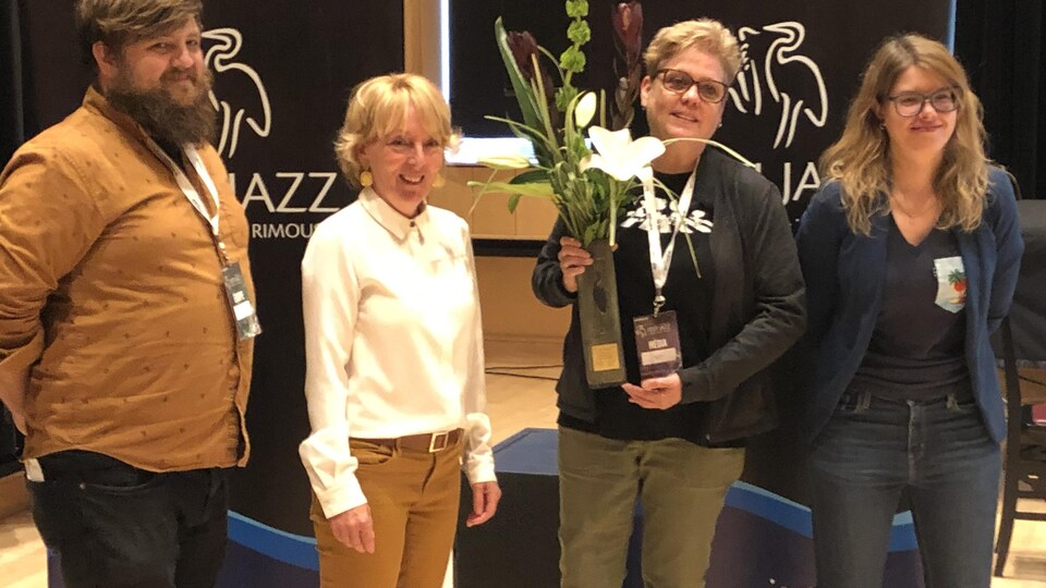 Colette Schryburt reçoit le prix Héron et pose en compagnie de trois autres personnes.