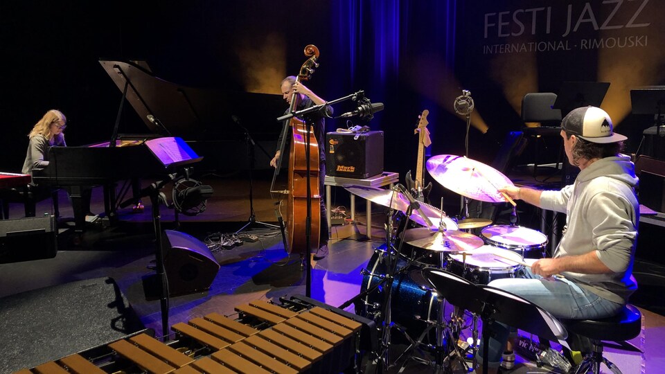 En compagnie d'un violoncelliste et d'un percussionniste, Emie R Roussel est au piano sur scène.