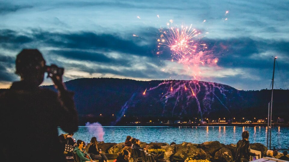 Un feu d'artifice dans le ciel derrière les spectateurs du festival BleuBleu.