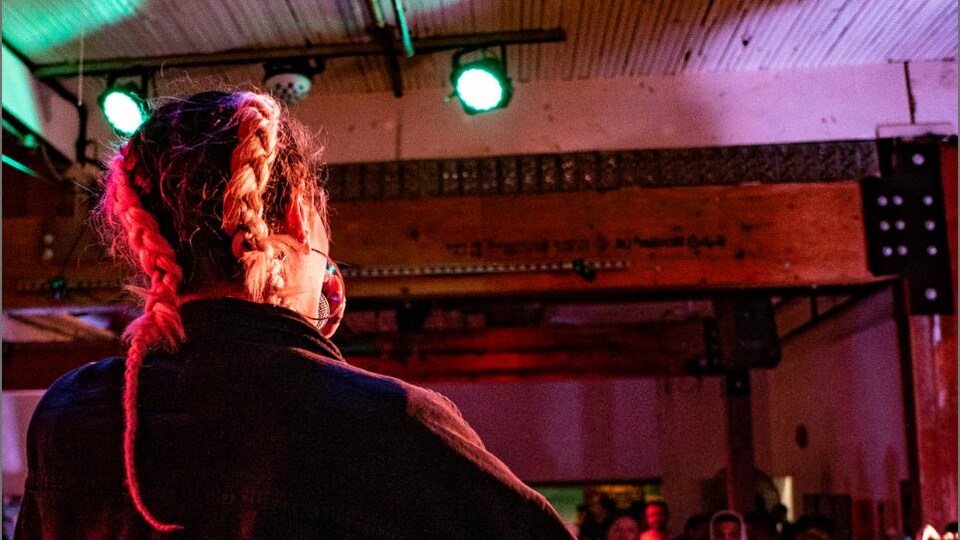 Photographie d'une chanteuse de dos sur scène devant son public.