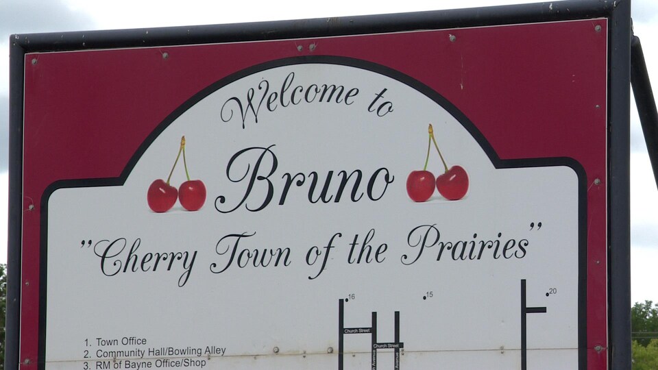 Pancarte rouge de la ville indiquant bienvenue à Bruno, la Ville cerise des Prairies.
