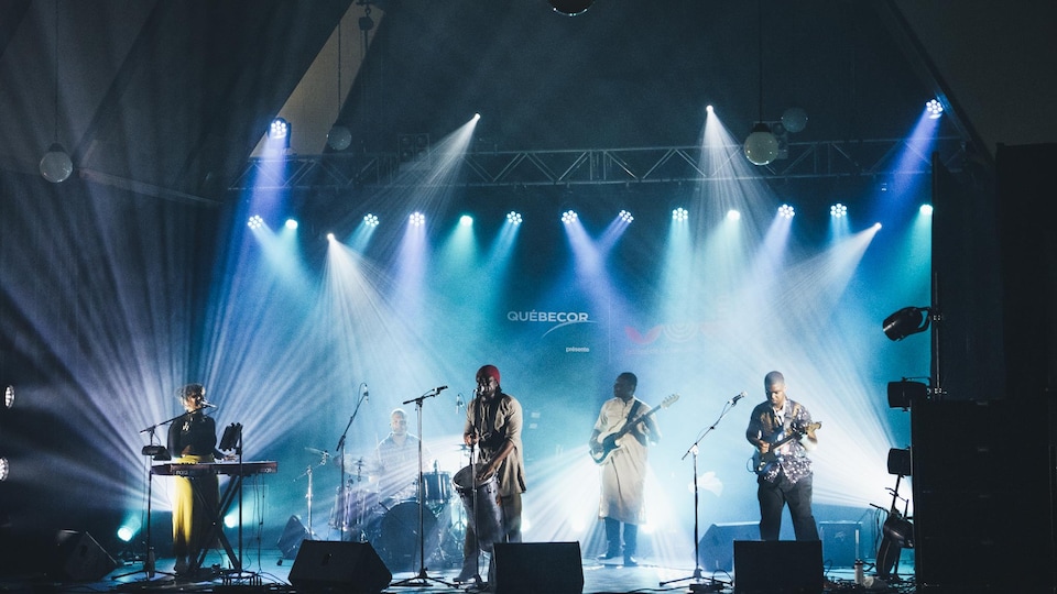 Cinq musiciens sur scène, en spectacle.