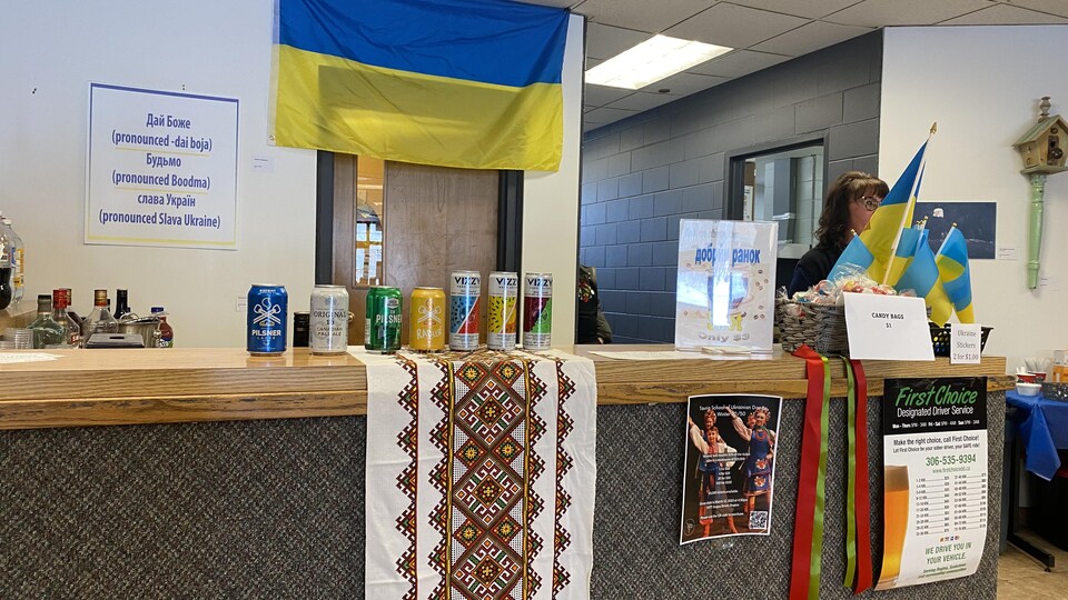 Un kiosque où on voit des canettes de boissons et le drapeau ukrainien.
