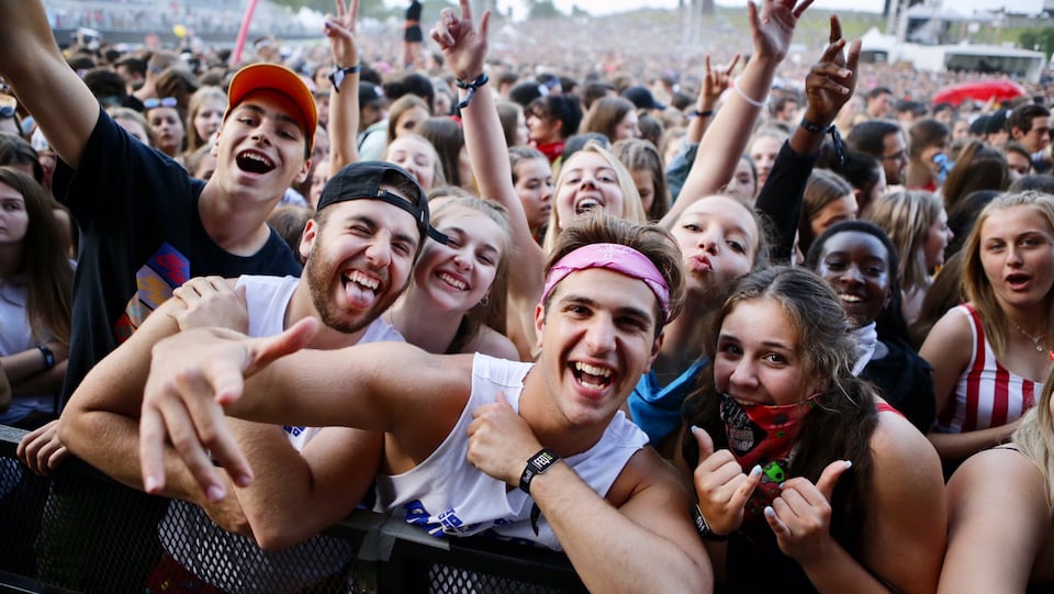 De jeunes festivaliers devant une scène, souriants.