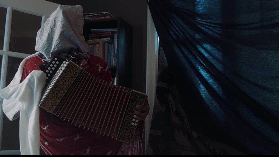 Un mummer joue de l'accordéon.