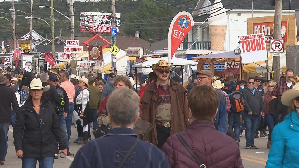 Des gens dans la rue avec des chapeaux de cowboys.