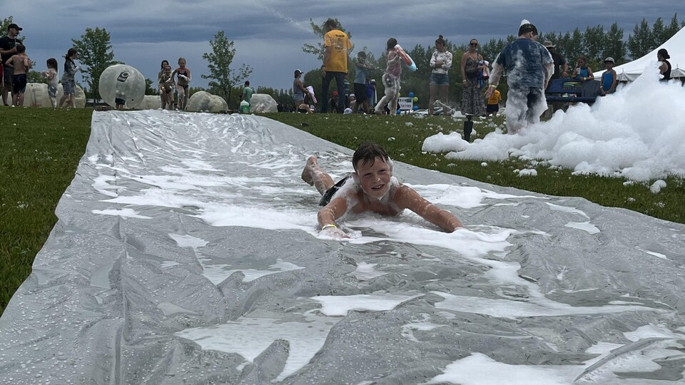 Des enfants s'amusent avec un canon à mousse.