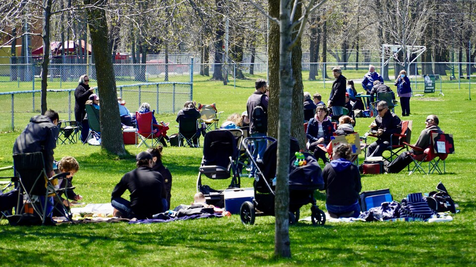 Des familles installées sur des couvertures dans un parc
