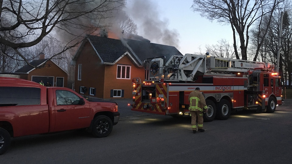Une maison orange avec des flammes sur le toit.
