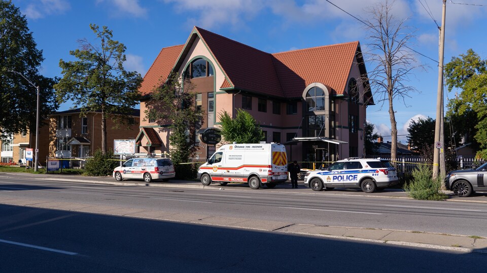 Des voitures de la police et des pompiers d'Ottawa devant un édifice.
