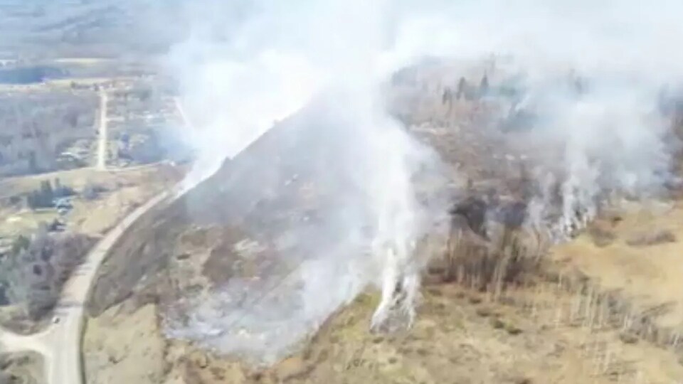 Deux petites colonnes de fumées s'élèvent dans le ciel lors du feu de broussailles près de Kitwanga.