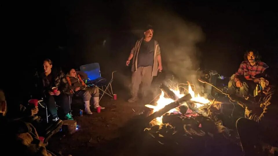 Des personnes autour d'un feu de camp.