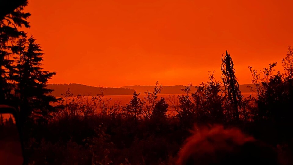 Ciel couleur feu, avec vue sur l'eau.