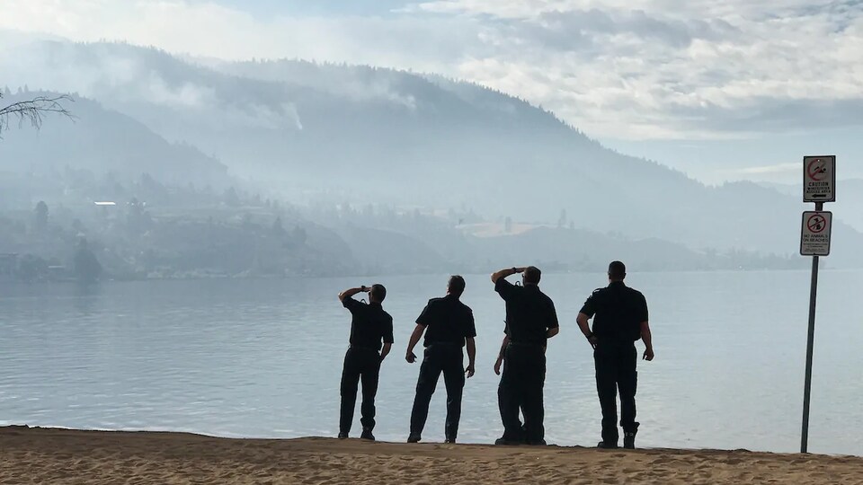 Les pompiers de Kelowna observent l'incendie de forêt à partir du côté est du lac Skaha, près de Penticton, en Colombie-Britannique.