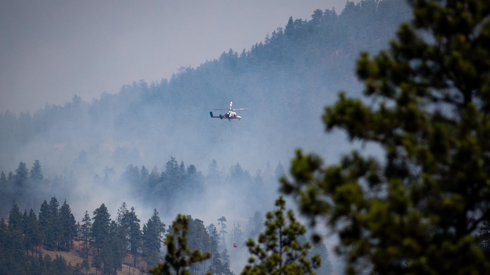 A helicopter prepares to pour water on a fire near Lytton. 