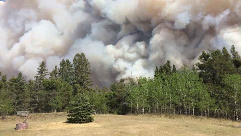 La fumée s'élevant du feu de forêt en bordure de Prince Albert, en Saskatchewan, le 17 mai 2021.