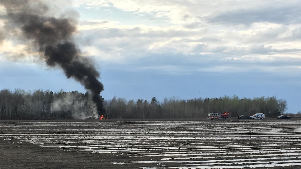 Black smoke on a farm with a fire truck.