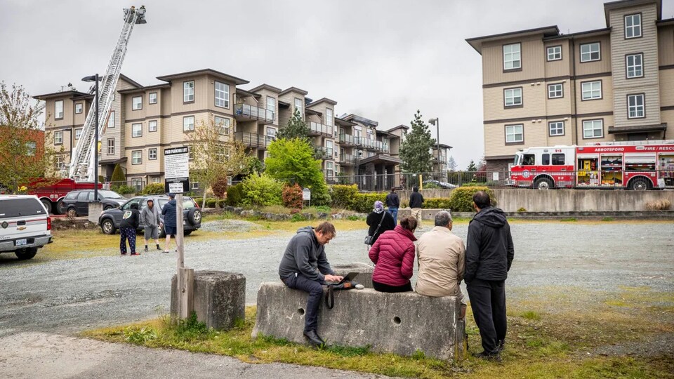 Residents sit outside the housing complex in Abbotsford, May 3, 2022. 