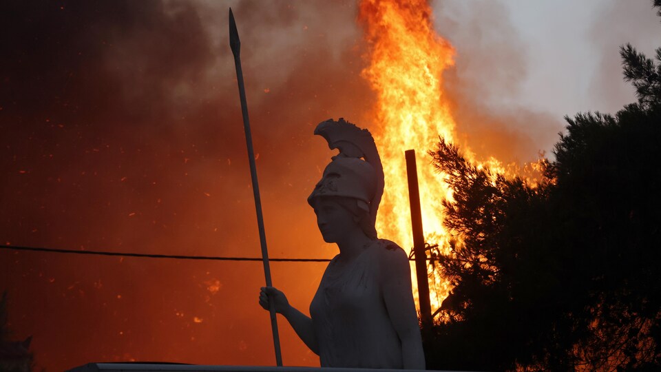 Des flammes près d'une statue.