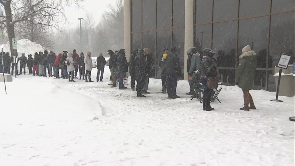 Des gens attendent en file.