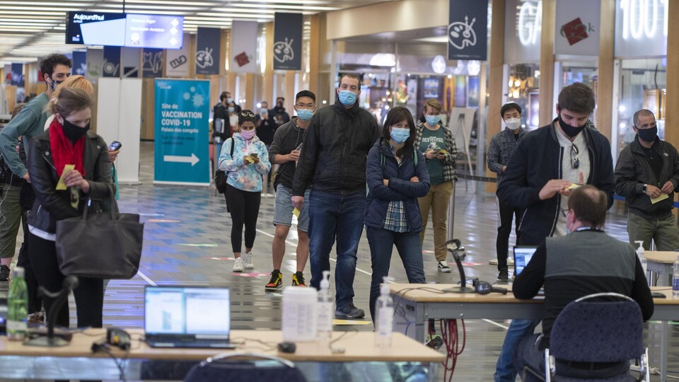 Des gens font la file dans une clinique de vaccination de Montréal.