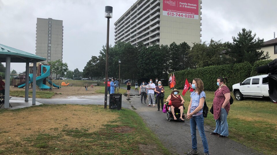 Une file de personnes masquées dans un parc d'Ottawa.