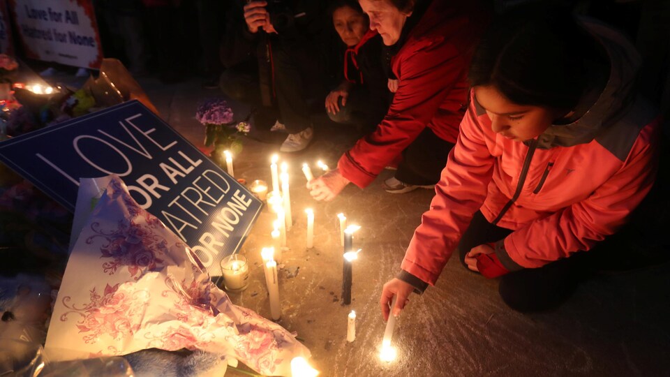 Une fille allume une chandelle à la place Mel Lastman de Toronto, lors de la veillée tenue en l’honneur des victimes de l’attaque au camion-bélier du 23 avril 2018.
