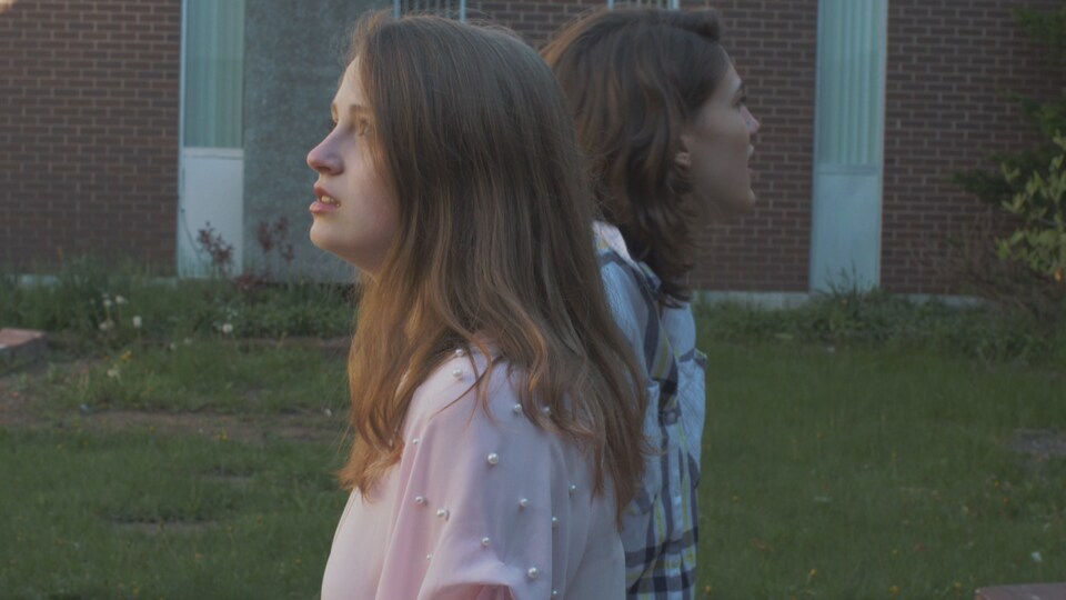 Deux jeunes actrices dans une scène du film se lancent des répliquent dans la cour de l'école