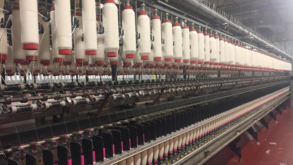 Filspec produit du fil spécialisé à Sherbrooke. On aperçoit ici l'intérieur de l'usine, plusieurs bobines de fil en rangée. 