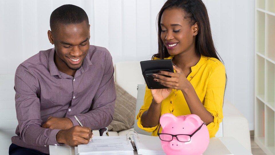 Un couple heureux fait des calculs financiers