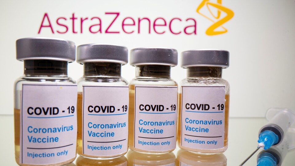 Des fioles sur lesquelles on peut lire "COVID-19 Coronavirus vaccine injections only", avec le logo d'AstraZeneca en arrière-plan. 