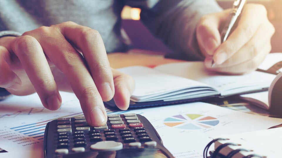 Gros plan sur un homme utilisant une calculatrice.