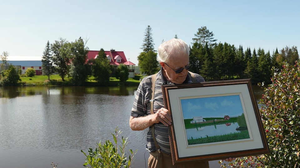 Un homme montre une toile illustrant ce dont avait l'air la terre ancestrale.